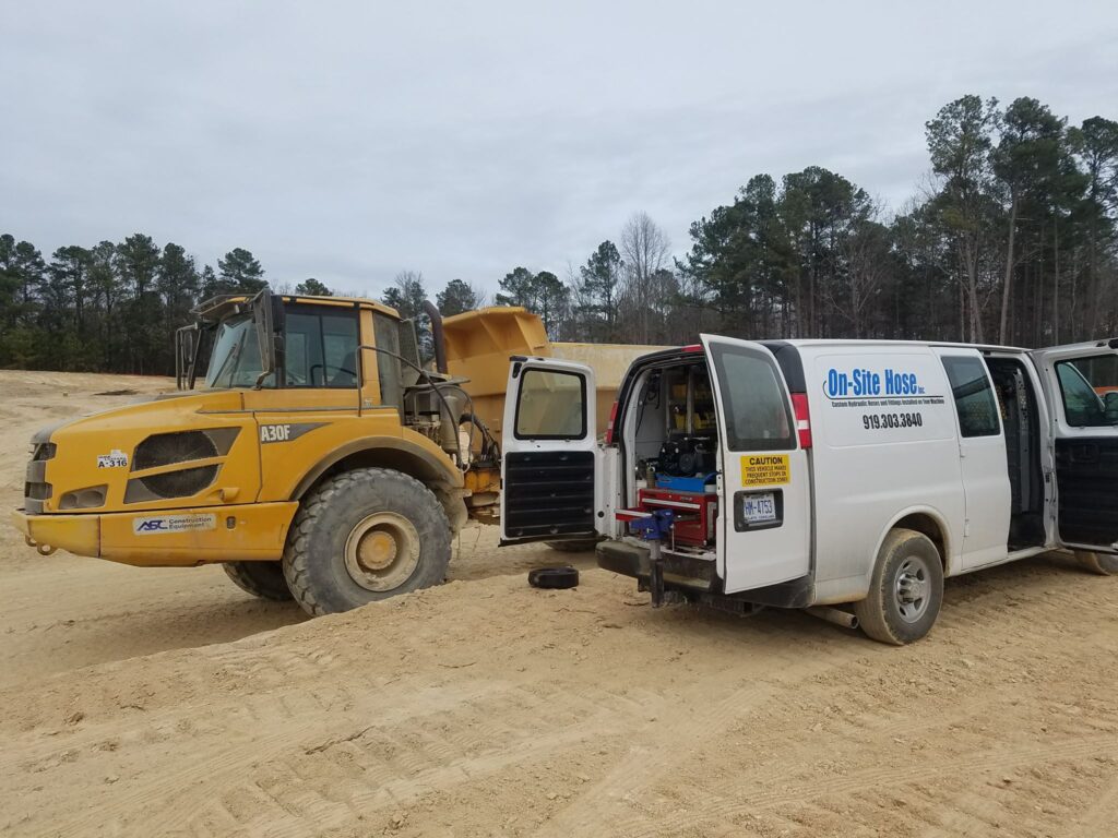 Technician performing mobile hose repair on equipment